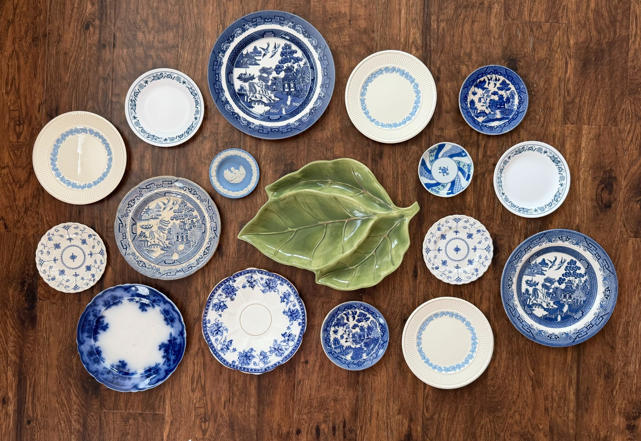 Large blue and white plate arrangement with a green leaf centerpiece
