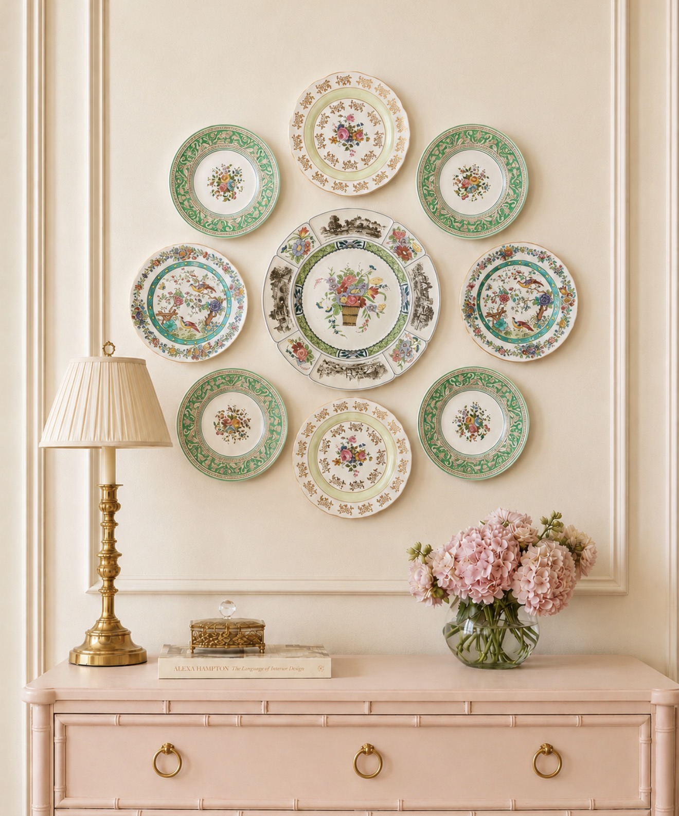 Green and floral plate wall above a pale pink bamboo dresser
