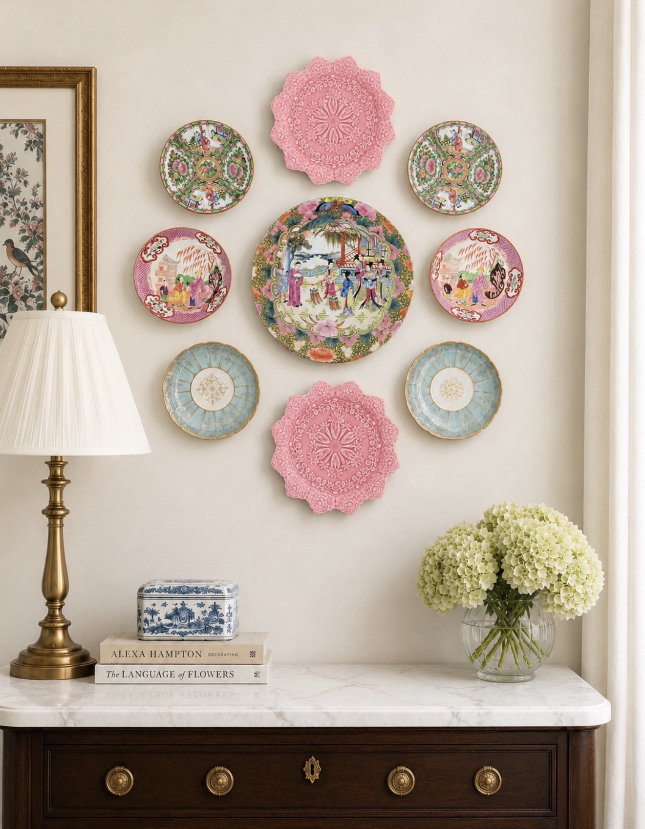 Colorful pink and chinoiserie plate wall above a dark wood sideboard