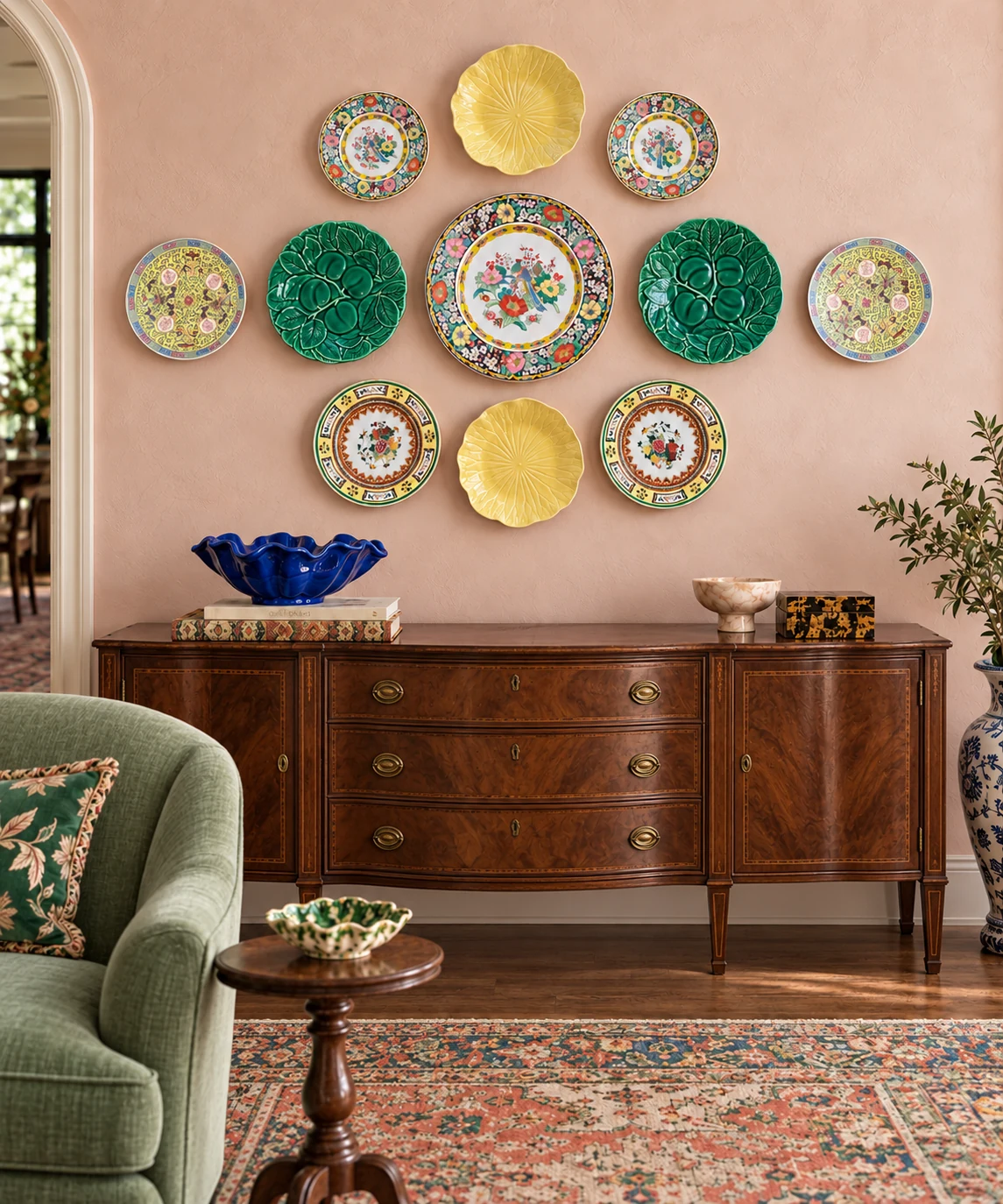 Colorful plate wall in pink, green and yellow above an antique wood sideboard